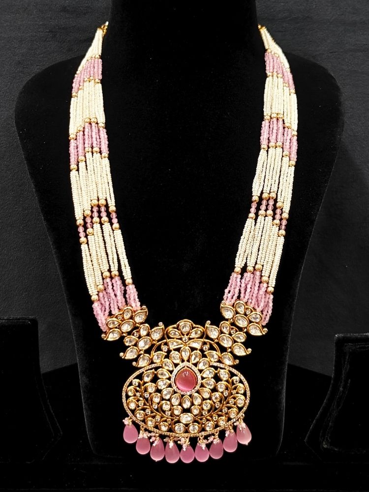 Close-up of an ornate traditional (Gold Polish) Mint Pink Long jewellery set and earrings with Polki, American Diamond, Pearls, Crystal Beads and Tumble Beads. Wedding guest wearing a statement Polki artificial necklace for a reception party. Festive celebration look completed with premium imitation Polki jewelry.