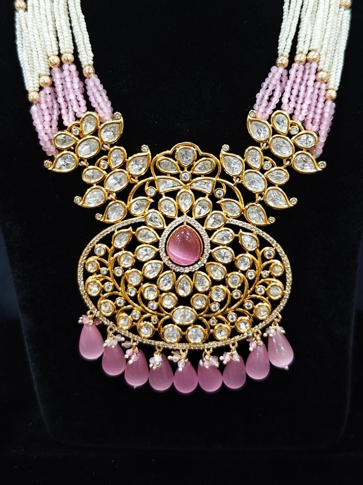 Close-up of an ornate traditional (Gold Polish) Mint Pink Long jewellery set and earrings with Polki, American Diamond, Pearls, Crystal Beads and Tumble Beads. Wedding guest wearing a statement Polki artificial necklace for a reception party. Festive celebration look completed with premium imitation Polki jewelry.