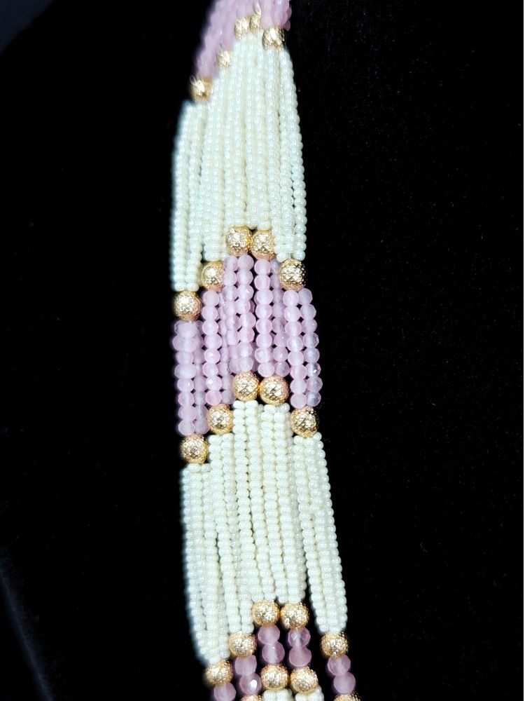 Close-up of an ornate traditional (Gold Polish) Mint Pink Long jewellery set and earrings with Polki, American Diamond, Pearls, Crystal Beads and Tumble Beads. Wedding guest wearing a statement Polki artificial necklace for a reception party. Festive celebration look completed with premium imitation Polki jewelry.