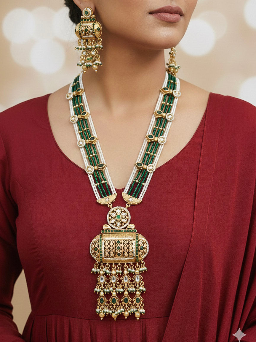 Close-up of a woman wearing an ornate traditional Dark Green Rajwadi gold Long jewellery set and earrings  with Pearls and Hydro Crystal. Woman styled in a royal Rajwadi artificial necklace set for a traditional Indian Festives. Model wearing a royal Rajwadi necklace set for Wedding celebrations in India.