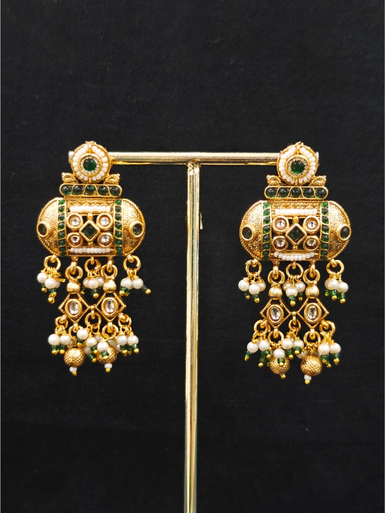 Close-up of an ornate traditional Dark Green Rajwadi gold Long jewellery set and earrings  with Pearls and Hydro Crystal. Festive look completed with a luxury Rajwadi imitation necklace. Wedding guest styling a Rajwadi artificial necklace.
