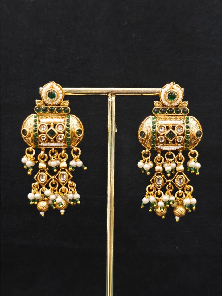 Close-up of an ornate traditional Dark Green Rajwadi gold Long jewellery set and earrings  with Pearls and Hydro Crystal. Festive look completed with a luxury Rajwadi imitation necklace. Wedding guest styling a Rajwadi artificial necklace.