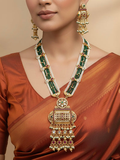 Close-up of a woman wearing an ornate traditional Red and Green Rajwadi gold Long jewellery set and earrings  with Pearls and Hydro Crystal. Bride wearing a premium Rajwadi necklace with a saree for her reception. Festive Diwali outfit enhanced with a Rajwadi artificial necklace.