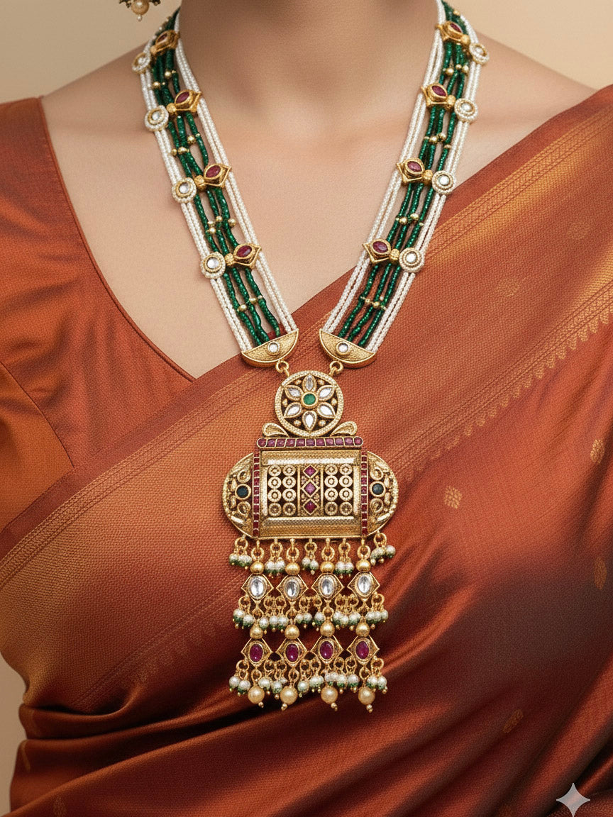 Close-up of a woman wearing an ornate traditional Red and Green Rajwadi gold Long jewellery set and earrings  with Pearls and Hydro Crystal. Bride wearing a premium Rajwadi necklace with a saree for her reception. Festive Diwali outfit enhanced with a Rajwadi artificial necklace.