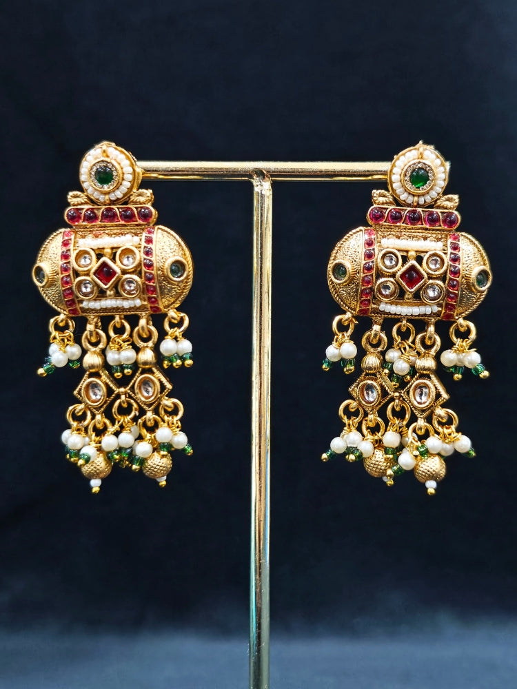 Close-up of an ornate traditional Red and Green Rajwadi gold Long jewellery set and earrings  with Pearls and Hydro Crystal. Festive Diwali outfit enhanced with a Rajwadi artificial necklace. Close-up of detailed Rajwadi craftsmanship in artificial jewelry.