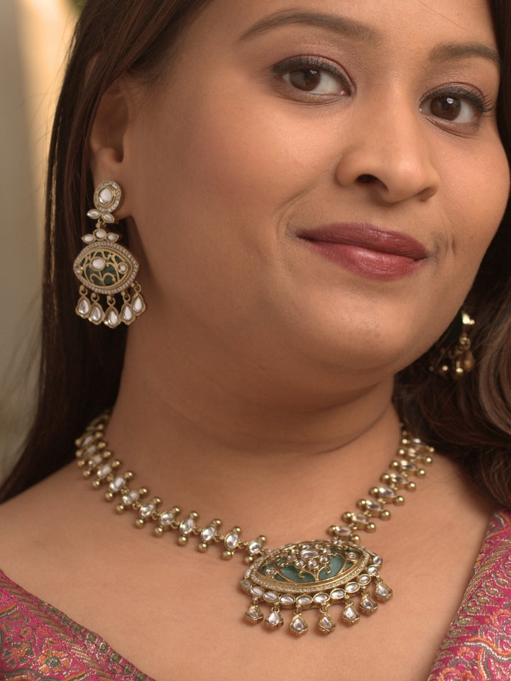 Close-up of a woman wearing an ornate traditional (Mehendi Polish Antique Finish) Sea Green Collar jewellery set and earrings with Kundan, Monalisa Stone, Colored Stones and American Diamond. Woman wearing trending Kundan artificial jewelry for wedding season in India. Festive Diwali outfit paired with a premium Kundan jewelry piece.