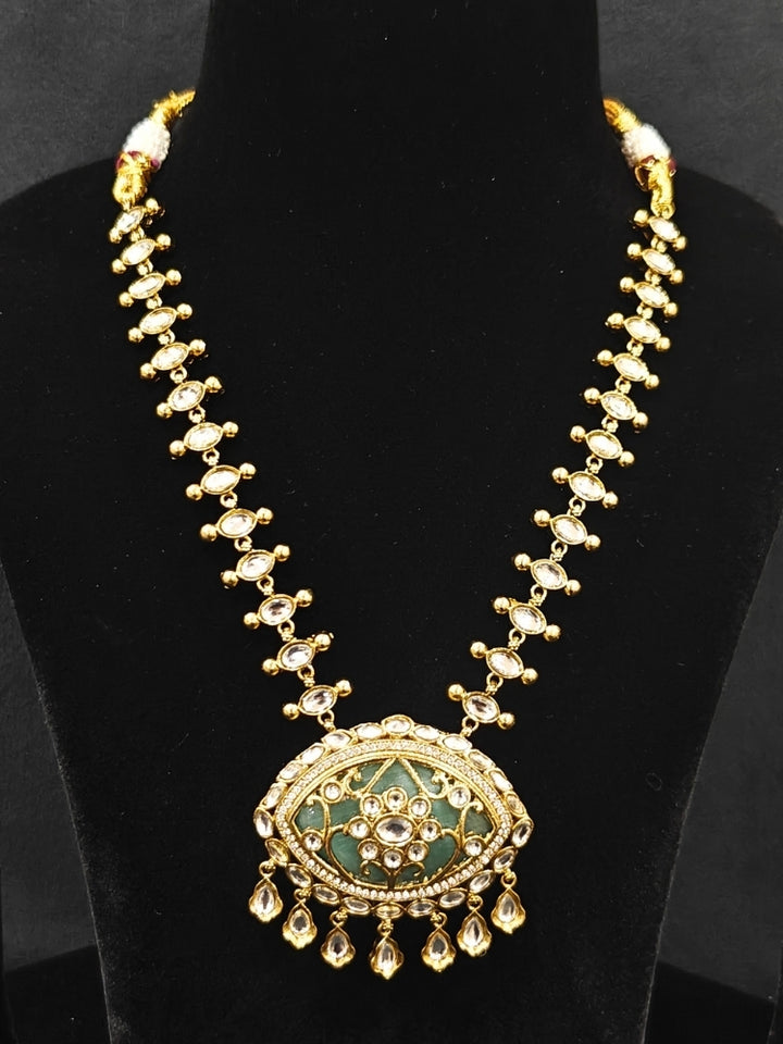 Close-up of an ornate traditional (Mehendi Polish Antique Finish) Sea Green Collar jewellery set and earrings with Kundan, Monalisa Stone, Colored Stones and American Diamond. A trending Kundan artificial jewelry for wedding season in India. Festive Diwali outfit paired with a premium Kundan jewelry piece.