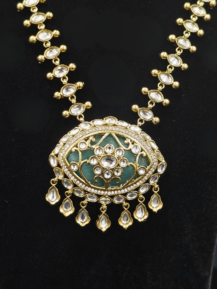 Close-up of an ornate traditional (Mehendi Polish Antique Finish) Sea Green Collar jewellery set and earrings with Kundan, Monalisa Stone, Colored Stones and American Diamond. A trending Kundan artificial jewelry for wedding season in India. Festive Diwali outfit paired with a premium Kundan jewelry piece.