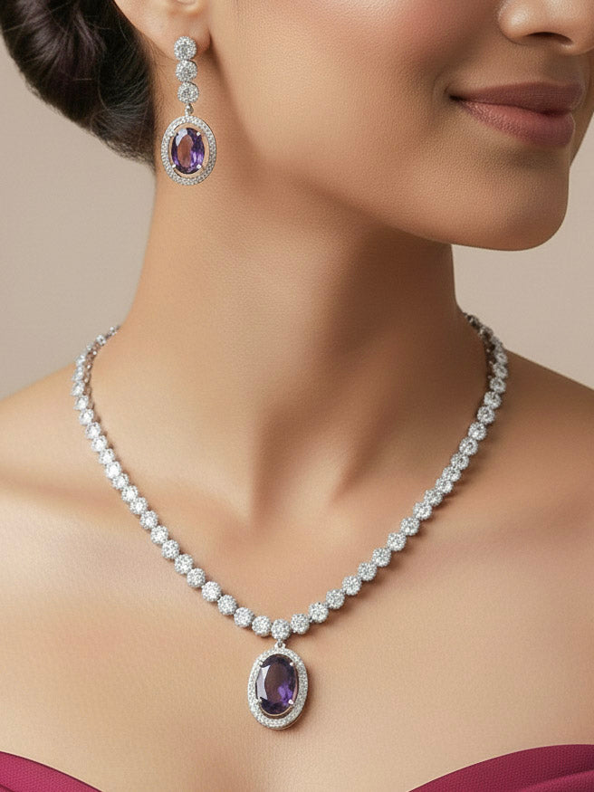 Close-up of a woman wearing an ornate Western Purple (Silver Gold) Collar jewellery set and earrings with American Diamond and Colored Stones. Reception-ready look featuring a statement American diamond jewelry set. Close-up of a cocktail party look featuring a premium American diamond necklace.