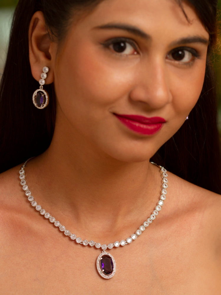 Close-up of a model in luxurious artificial diamond jewelry featuring a designer diamond necklace with purple colored stone and earrings set, crafted for bridal fashion and high-end weddings. This beautiful diamond jewelry set offers the brilliance of real diamonds at an affordable price.