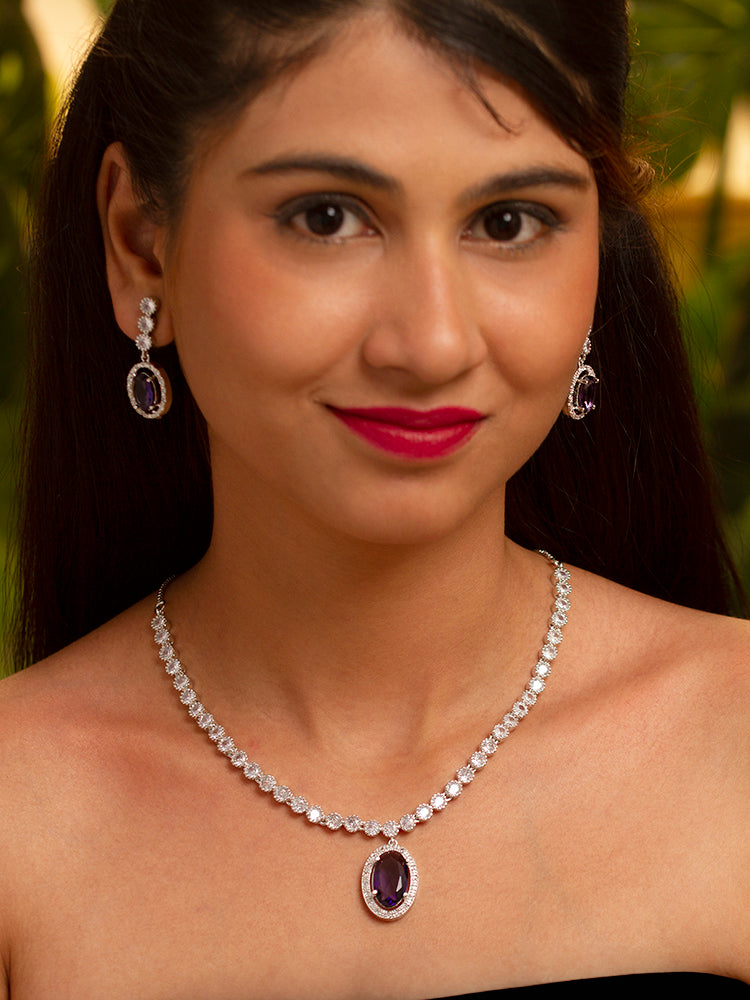 Elegant woman wearing a luxurious artificial diamond necklace with purple colored stone matching earrings, perfect for high-profile wedding receptions and formal galas. This high-end artificial diamond jewelry set combines style, elegance, and affordability for special occasions.