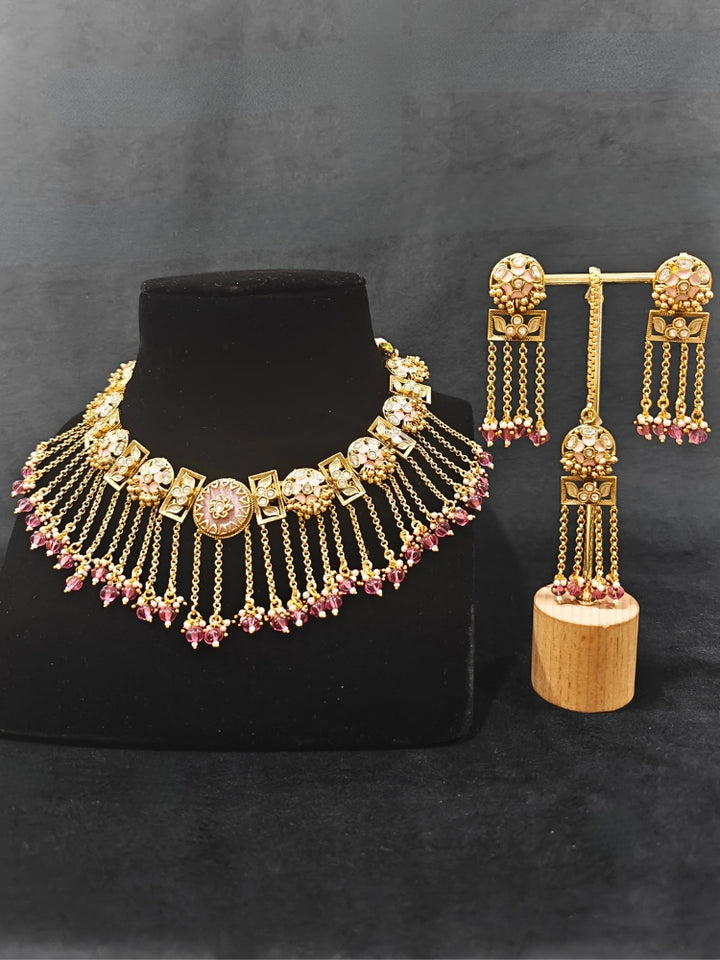 Close-up of an ornate traditional Mint Pink Heritage gold Collar jewellery set and earrings and maangtikka with Beads, Colored Stones and Kundan. A heritage-inspired artificial necklace for wedding festivities. Saree styling inspiration with a traditional heritage necklace.