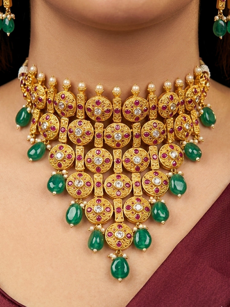 Close-up of a women wearing an ornate traditional (Gold Polish) Choker jewellery set and earrings with Pearls, Green Beads and Colored Stones. Wedding guest look featuring a statement imitation jewelry set. Wedding guest outfit enhanced with elegant artificial jewelry.