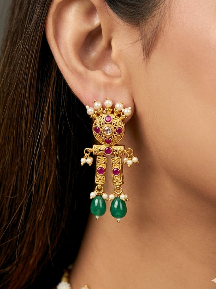 Close-up of a women wearing an ornate traditional (Gold Polish) Choker jewellery set and earrings with Pearls, Green Beads and Colored Stones. Wedding guest look featuring a statement imitation jewelry set. Wedding guest outfit enhanced with elegant artificial jewelry.