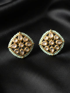 Close-up of an ornate traditional (Gold Polish) Mint Green Studs Earrings with Kundan, Crystal Beads and Green Colored Stones in Mid. Mehendi ceremony look completed with a handcrafted Kundan Studs Earrings. Festive Diwali outfit paired with a premium Kundan Studs Earrings.