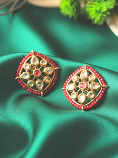 Close-up of an ornate traditional (Gold Polish) Red Studs Earrings with Kundan, Crystal Beads and Red Colored Stones in Mid. Mehendi ceremony look completed with a handcrafted Kundan Studs Earrings. Festive Diwali outfit paired with a premium Kundan Studs Earrings.