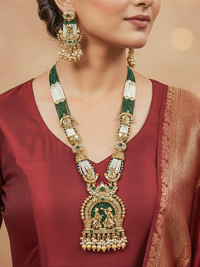 Close-up of a woman wearing an ornate traditional Dark Green Rajwadi gold Long jewellery set and earrings  with Pearls, Hydro Crystal and Bandhai Work. Woman styled in a royal Rajwadi artificial necklace set for a traditional Indian wedding.
Woman wearing a bridal Rajwadi necklace for a reception function.
