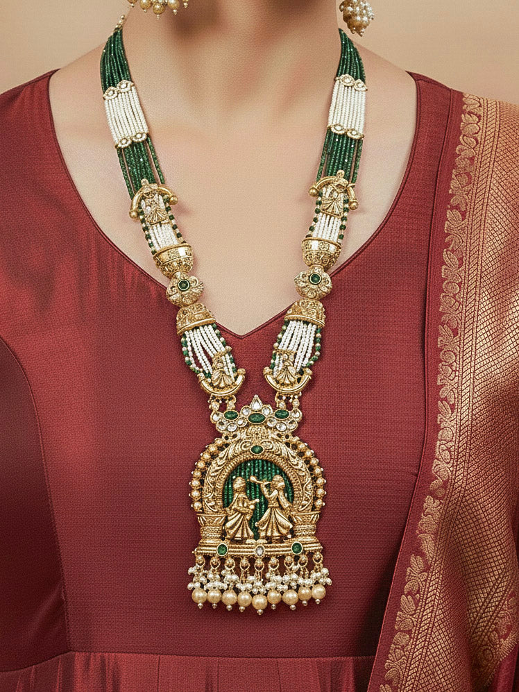 Close-up of a woman wearing an ornate traditional Dark Green Rajwadi gold Long jewellery set and earrings  with Pearls, Hydro Crystal and Bandhai Work. Woman styled in a royal Rajwadi artificial necklace set for a traditional Indian wedding.
Woman wearing a bridal Rajwadi necklace for a reception function.