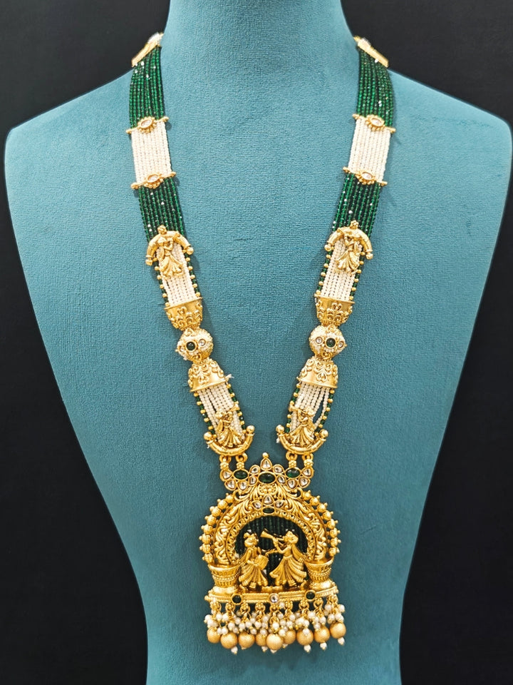 Close-up of an ornate traditional Dark Green Rajwadi gold Long jewellery set and earrings  with Pearls, Hydro Crystal and Bandhai Work. Close-up of detailed Rajwadi craftsmanship in artificial jewelry.
Traditional Indian look featuring a Rajwadi necklace set. Perfect  Rajwadi necklace set for weddings and festivals
