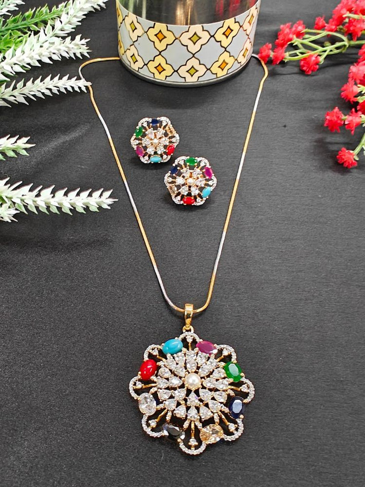 Close-up of an ornate Indo-western Navratan (gold polish) Diamond Pendant set and earrings with American Diamond and Colored Stones. Festive Diwali, Navratri outfit styled with an American diamond artificial Pendant. Indo-western outfit styled with a statement American diamond Pendant set.