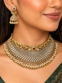 Close-up of a women wearing an ornate traditional (Gold Polish) Choker jewellery set and earrings with American Diamond and Pearls. A woman wearing a luxury American diamond necklace set styled beautifully for a wedding guest look in India. Elegant wedding jewelry look featuring a premium artificial American diamond necklace.