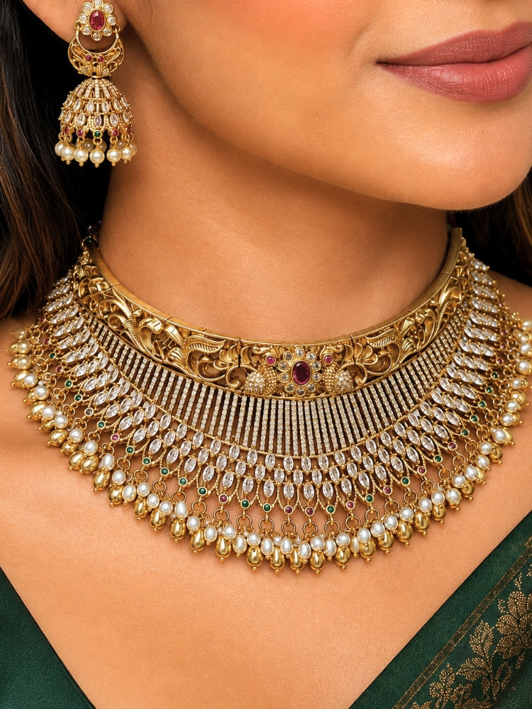 Close-up of a women wearing an ornate traditional (Gold Polish) Choker jewellery set and earrings with American Diamond and Pearls. A woman wearing a luxury American diamond necklace set styled beautifully for a wedding guest look in India. Elegant wedding jewelry look featuring a premium artificial American diamond necklace.