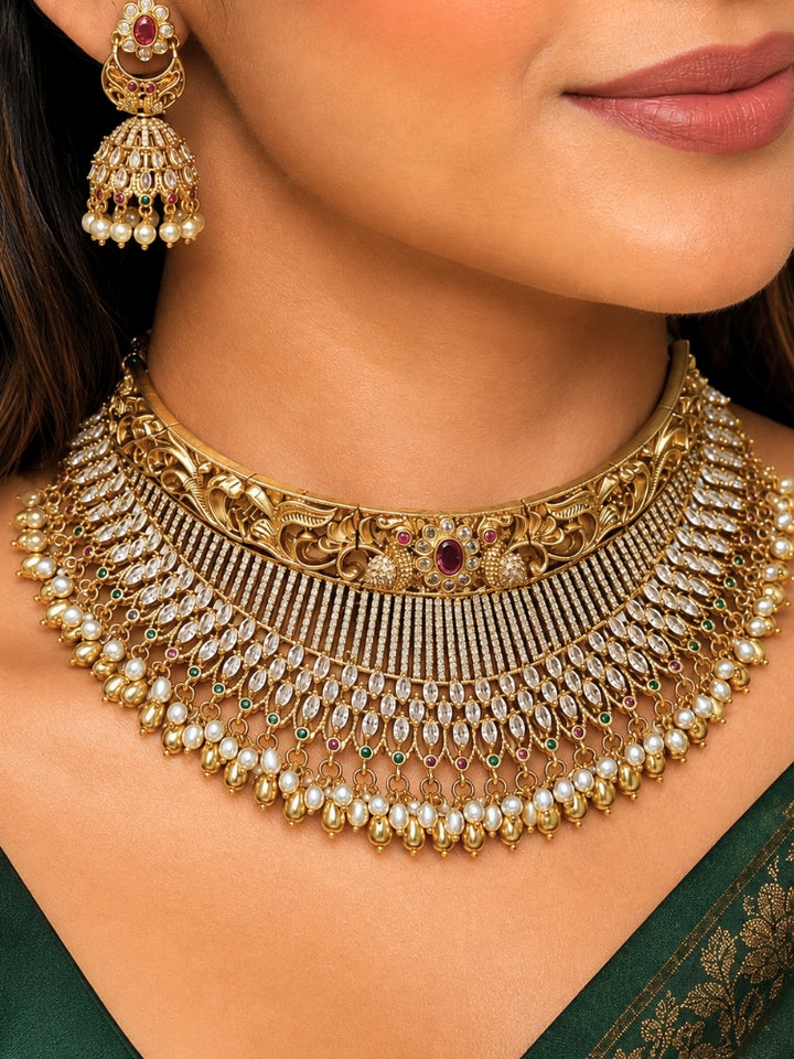 Close-up of a women wearing an ornate traditional (Gold Polish) Choker jewellery set and earrings with American Diamond and Pearls. A woman wearing a luxury American diamond necklace set styled beautifully for a wedding guest look in India. Elegant wedding jewelry look featuring a premium artificial American diamond necklace.