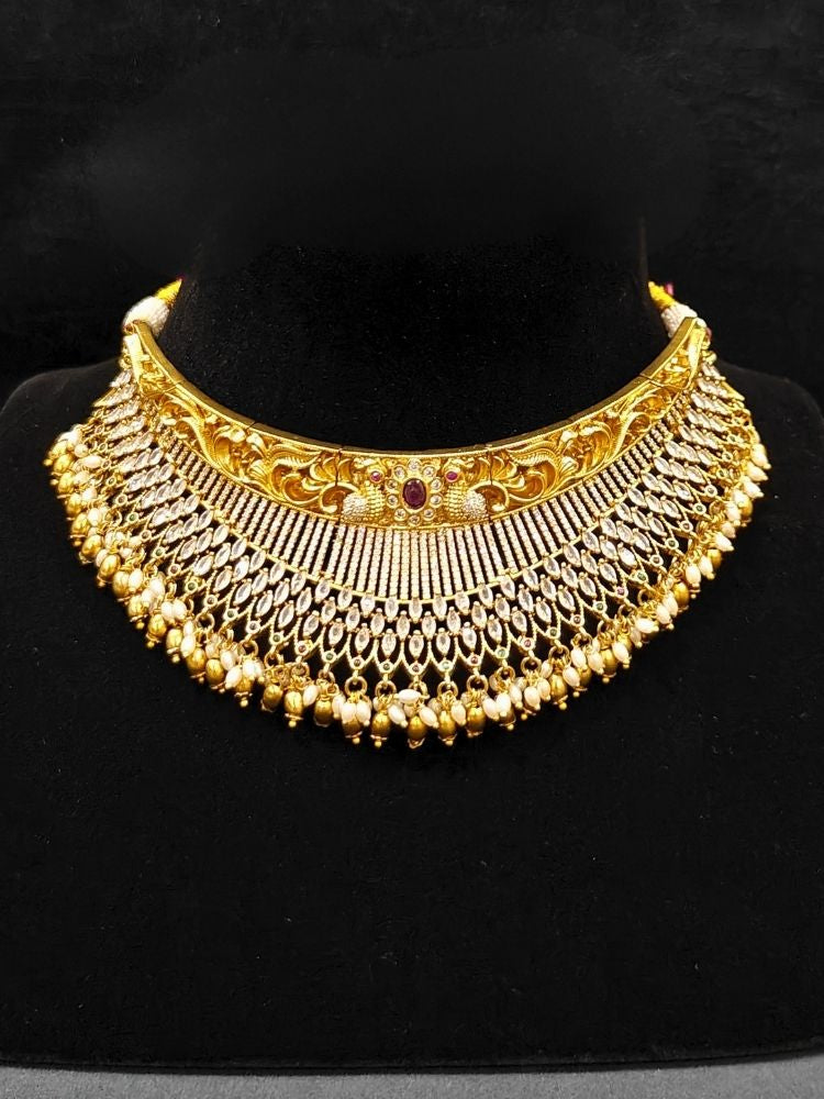 Close-up of an ornate traditional (Gold Polish) Choker jewellery set and earrings with American Diamond and Pearls. A woman wearing a luxury American diamond necklace set styled beautifully for a wedding guest look in India. Elegant wedding jewelry look featuring a premium artificial American diamond necklace.
