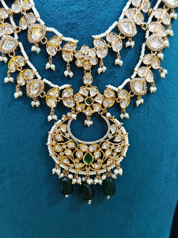 Close-up of an ornate traditional (Gold Polish) Green Long jewellery set and earrings with Polki, American Diamond and Pearl. Festive Diwali look enhanced with a premium Polki artificial necklace. Wedding guest outfit styled with an elegant Polki necklace set.Close-up of high-quality imitation Polki jewelry for bridal wear.
