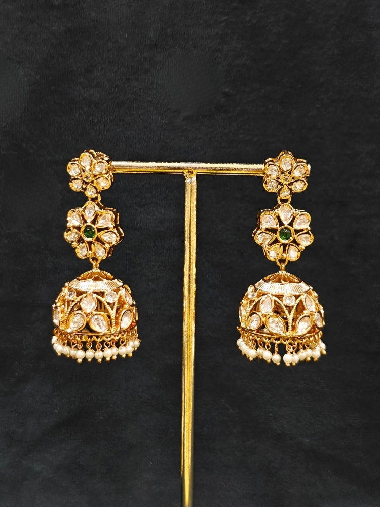 Close-up of an ornate traditional (Gold Polish) Green Long jewellery set and earrings with Polki, American Diamond and Pearl. Festive Diwali look enhanced with a premium Polki artificial necklace. Wedding guest outfit styled with an elegant Polki necklace set.Close-up of high-quality imitation Polki jewelry for bridal wear.