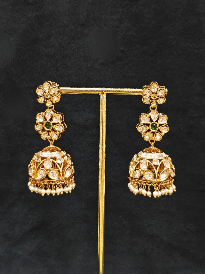 Close-up of an ornate traditional (Gold Polish) Green Long jewellery set and earrings with Polki, American Diamond and Pearl. Festive Diwali look enhanced with a premium Polki artificial necklace. Wedding guest outfit styled with an elegant Polki necklace set.Close-up of high-quality imitation Polki jewelry for bridal wear.