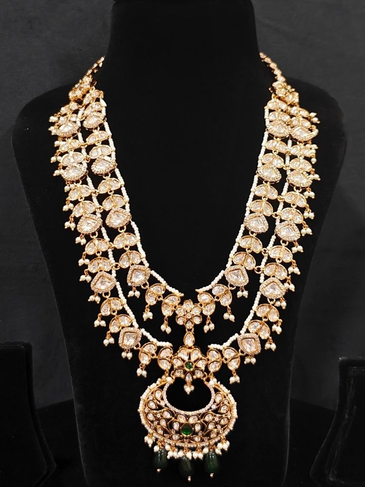 Close-up of an ornate traditional (Gold Polish) Green Long jewellery set and earrings with Polki, American Diamond and Pearl. Festive Diwali look enhanced with a premium Polki artificial necklace. Wedding guest outfit styled with an elegant Polki necklace set.Close-up of high-quality imitation Polki jewelry for bridal wear.