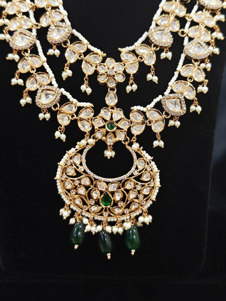 Close-up of an ornate traditional (Gold Polish) Green Long jewellery set and earrings with Polki, American Diamond and Pearl. Festive Diwali look enhanced with a premium Polki artificial necklace. Wedding guest outfit styled with an elegant Polki necklace set.Close-up of high-quality imitation Polki jewelry for bridal wear.