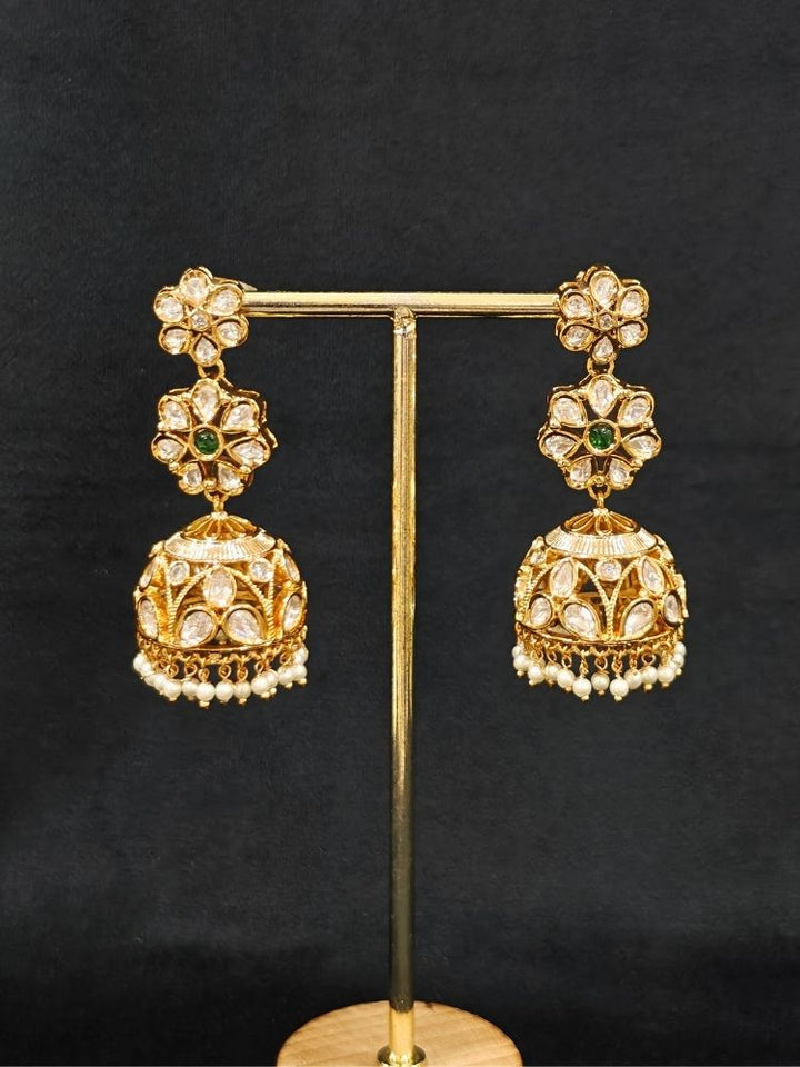 Close-up of an ornate traditional (Gold Polish) Green Long jewellery set and earrings with Polki, American Diamond and Pearl. Festive Diwali look enhanced with a premium Polki artificial necklace. Wedding guest outfit styled with an elegant Polki necklace set.Close-up of high-quality imitation Polki jewelry for bridal wear.