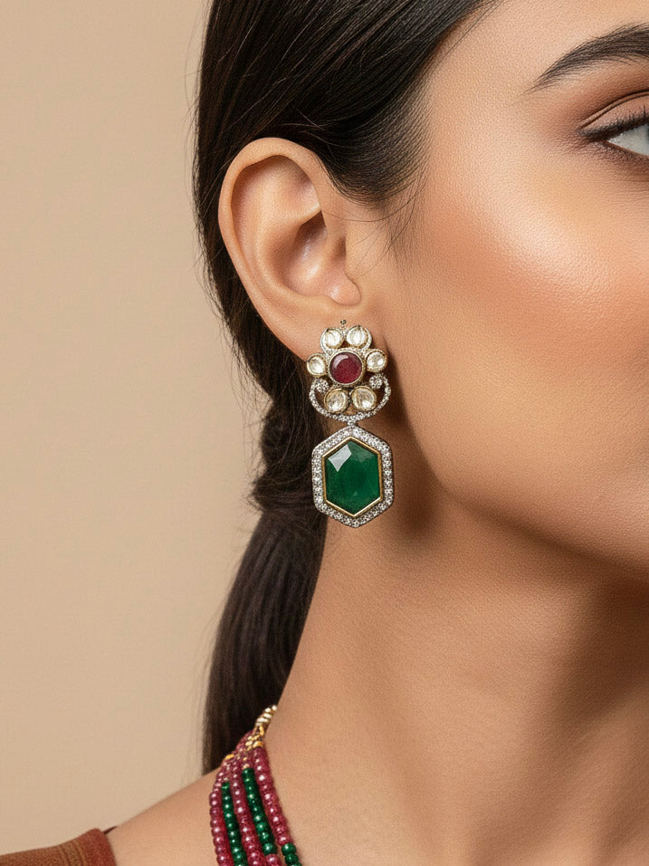 Close-up of a woman wearing an ornate traditional Diamond Ruby Red and Green jewellery set and earrings with Kundan, American Diamond, Monalisa Stones and Crystal Beads. A woman wearing a luxury American diamond necklace set styled beautifully for a wedding guest look in India. Elegant festive look with a high-quality imitation American diamond necklace set.