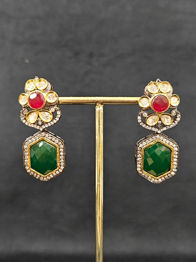 Close-up of an ornate traditional Diamond Ruby Red and Green jewellery set and earrings with Kundan, American Diamond, Monalisa Stones and Crystal Beads. A  luxury American diamond necklace set styled beautifully for a wedding guest look in India. Elegant festive look with a high-quality imitation American diamond necklace set.