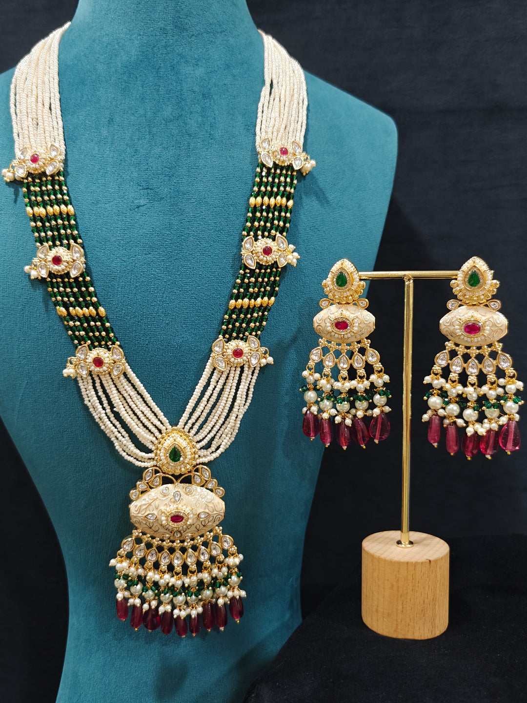 Close-up of an ornate traditional Ruby Pink and Green Rajwadi gold Long jewellery set and earrings  with Pearls, Beads, Meenakari and Moissanite Kundan. Festive look completed with a luxury Rajwadi imitation necklace. Close-up of a premium Rajwadi artificial necklace under 10000.