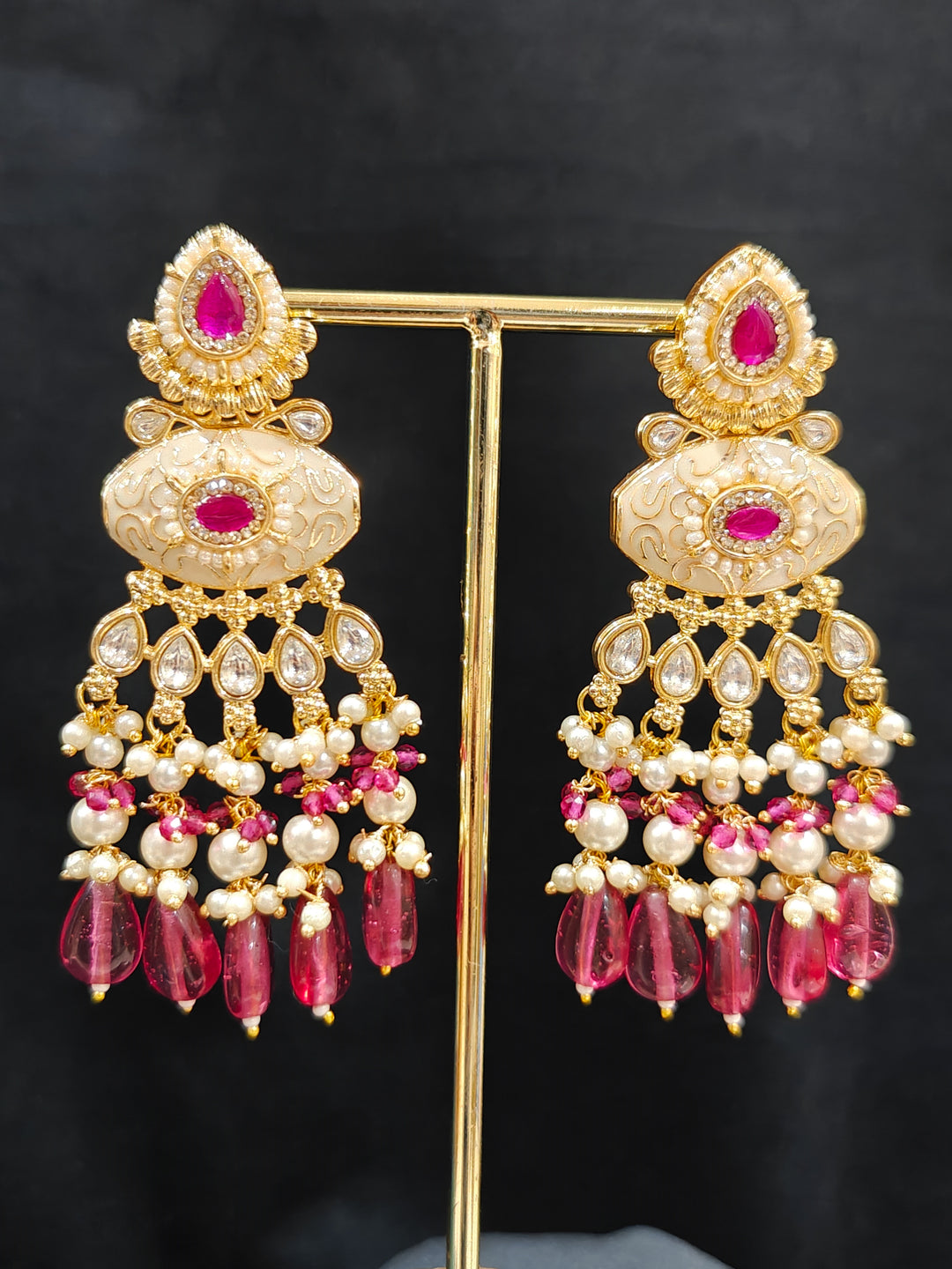 Close-up of an ornate traditional Ruby Pink Rajwadi gold Long jewellery set and earrings  with Pearls, Beads, Meenakari and Moissanite Kundan. Festive look completed with a luxury Rajwadi imitation necklace. Luxury imitation Rajwadi necklace worn for wedding celebrations.