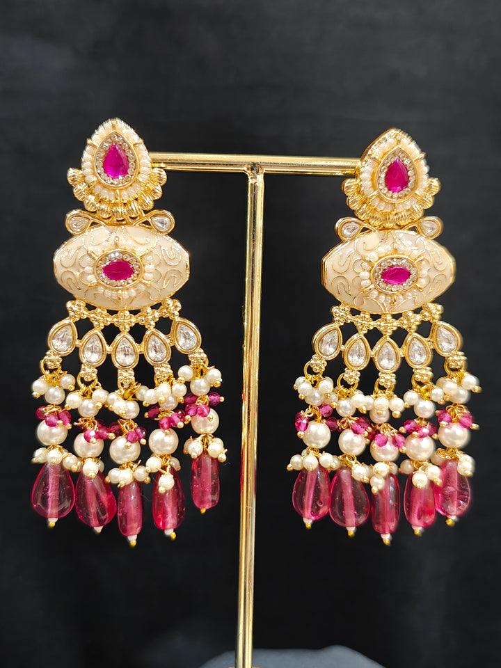Close-up of an ornate traditional Ruby Pink Rajwadi gold Long jewellery set and earrings  with Pearls, Beads, Meenakari and Moissanite Kundan. Festive look completed with a luxury Rajwadi imitation necklace. Luxury imitation Rajwadi necklace worn for wedding celebrations.