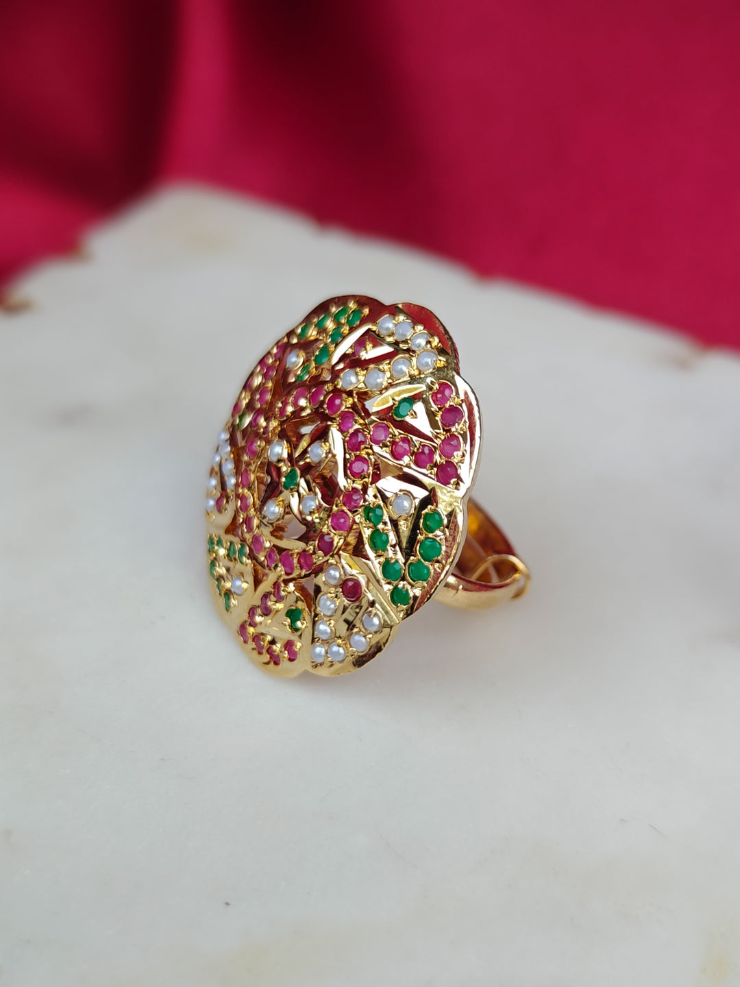 Close-up of an ornate traditional White, Multi-color jadau gold Ring with pearl and Color Stone. Close-up of handcrafted imitation Jadau ring for Festive wear. Perfect Jadau Ring for weddings and festivals.