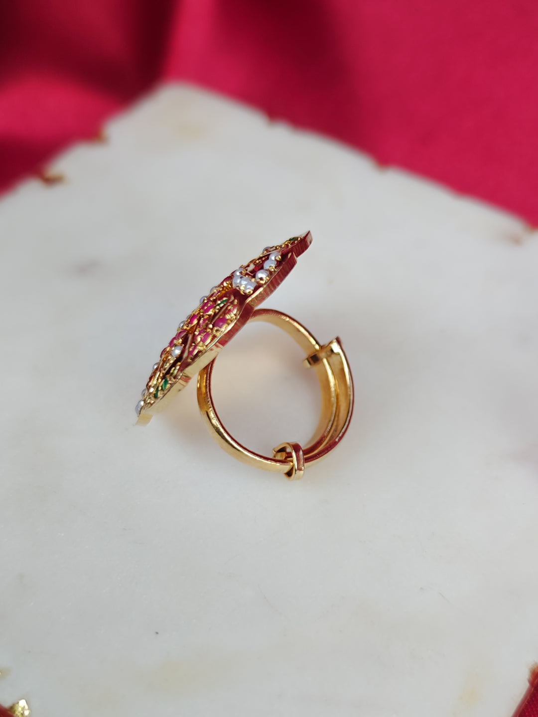 Close-up of an ornate traditional White, Multi-color jadau gold Ring with pearl and Color Stone. Close-up of handcrafted imitation Jadau ring for Festive wear. Perfect Jadau Ring for weddings and festivals.