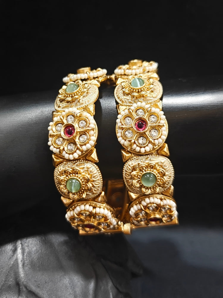 Close-up of an ornate traditional Rajwadi gold Bangle with Red & Mint Green Colored Stone, Bandhai Work and Meenakari. Festive celebration look enhanced with statement artificial  Rajwadi bangles. Perfect Rajwadi Bangles for weddings and festivals. Festive Diwali outfit paired with a colorful Meenakari Bangles.