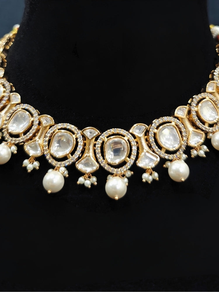 Close-up of an ornate traditional (Gold Polish) Collar jewellery set and earrings with Polki, American Diamond and Pearls. Festive saree look completed with a Polki artificial jewelry set. Woman wearing a lightweight Polki jewelry set for long wedding functions.