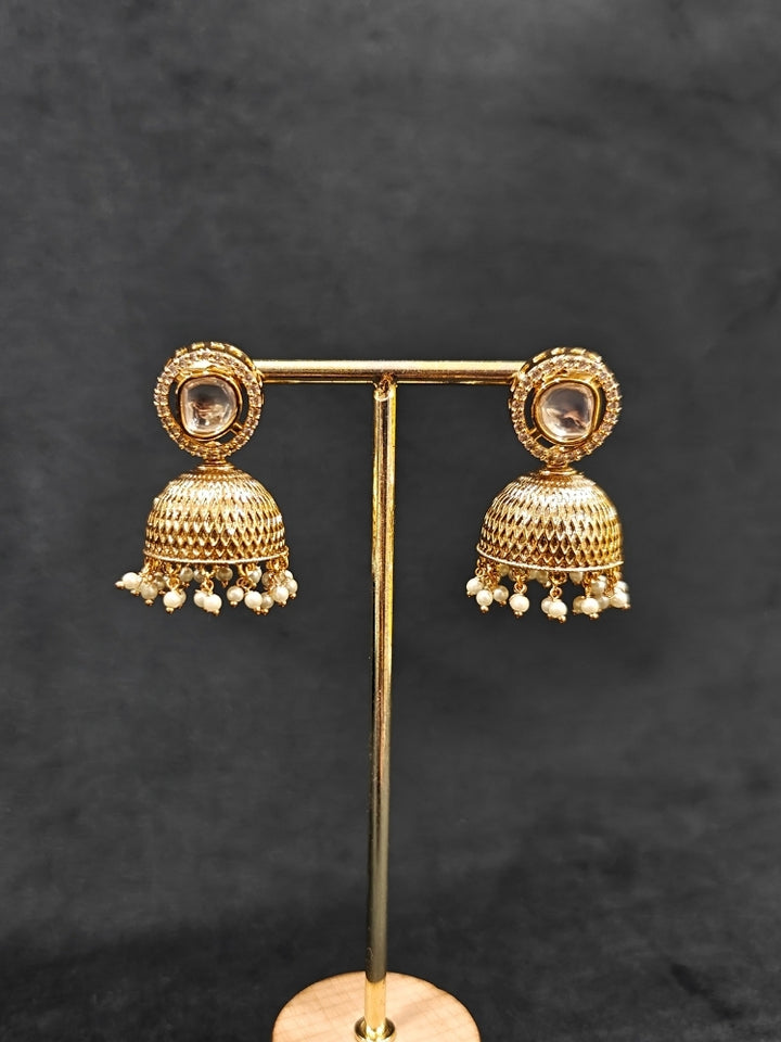 Close-up of an ornate traditional (Gold Polish) Collar jewellery set and earrings with Polki, American Diamond and Pearls. Festive saree look completed with a Polki artificial jewelry set. Woman wearing a lightweight Polki jewelry set for long wedding functions.