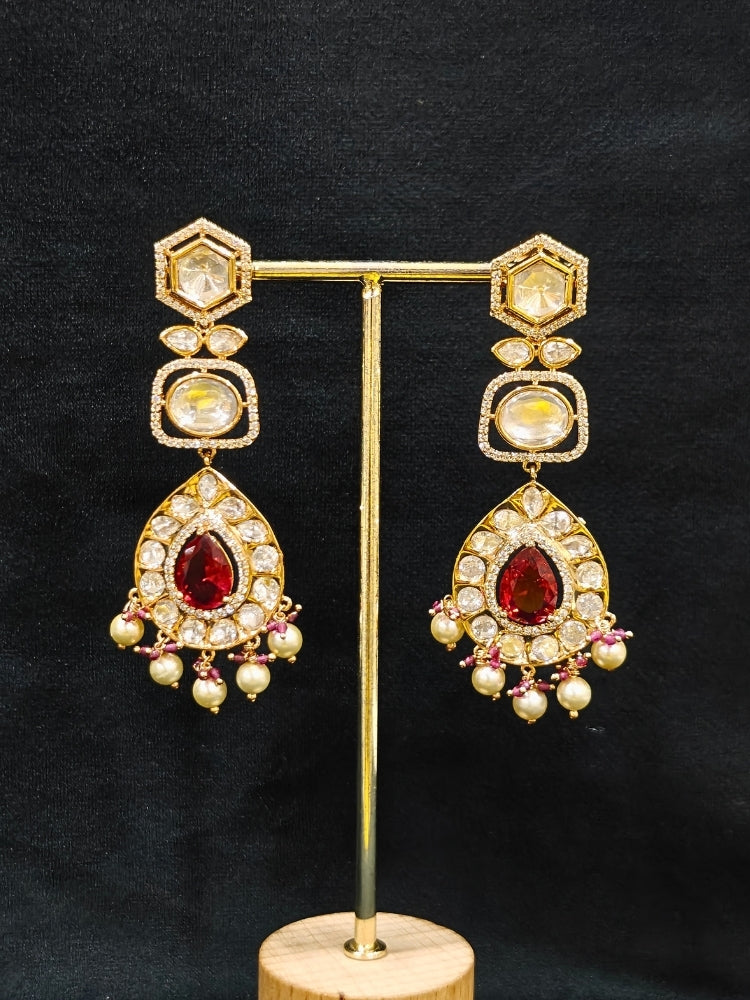 Close-up of an ornate traditional (Gold Polish) Layered Red jewellery set and earrings with Polki, American Diamond and Red Colored stones. Woman styling a premium Polki imitation necklace for wedding celebrations. Festive celebration look completed with premium imitation Polki jewelry.