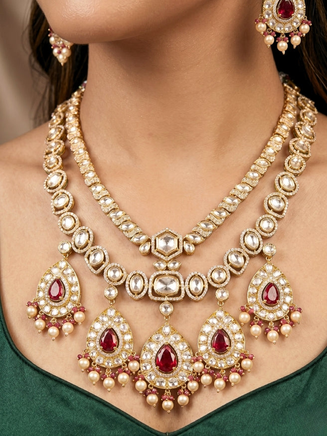 Close-up of a woman wearing an ornate traditional (Gold Polish) Layered Red jewellery set and earrings with Polki, American Diamond and Red Colored stones. Woman styling a premium Polki imitation necklace for wedding celebrations. Festive celebration look completed with premium imitation Polki jewelry.