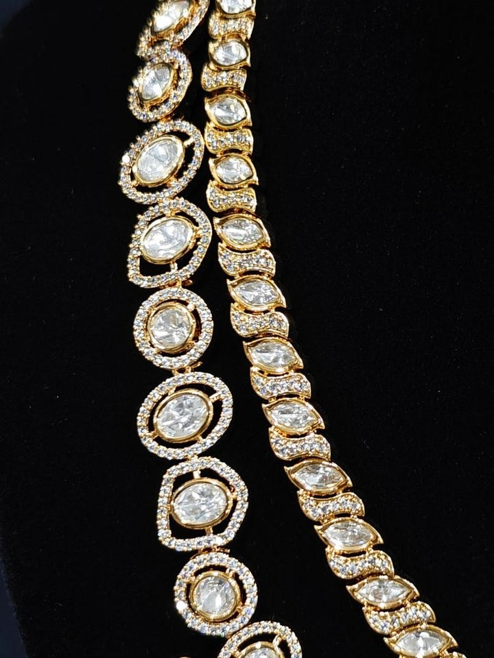 Close-up of an ornate traditional (Gold Polish) Layered Red jewellery set and earrings with Polki, American Diamond and Red Colored stones. Woman styling a premium Polki imitation necklace for wedding celebrations. Festive celebration look completed with premium imitation Polki jewelry.