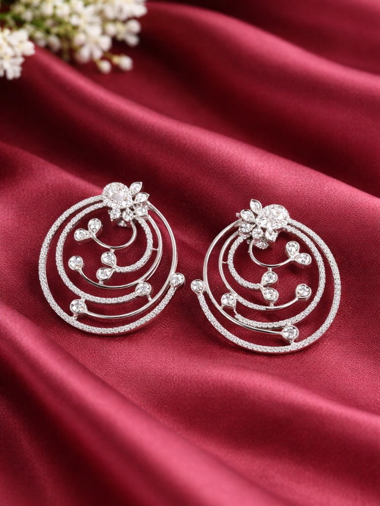Close-up of an ornate Western (Silver Polish) Diamond Studs Earrings with American Diamonds. Elegant party wear styled with high-quality imitation American Diamond Studs earrings. Close-up of sparkling American diamond Studs earrings for party wear.