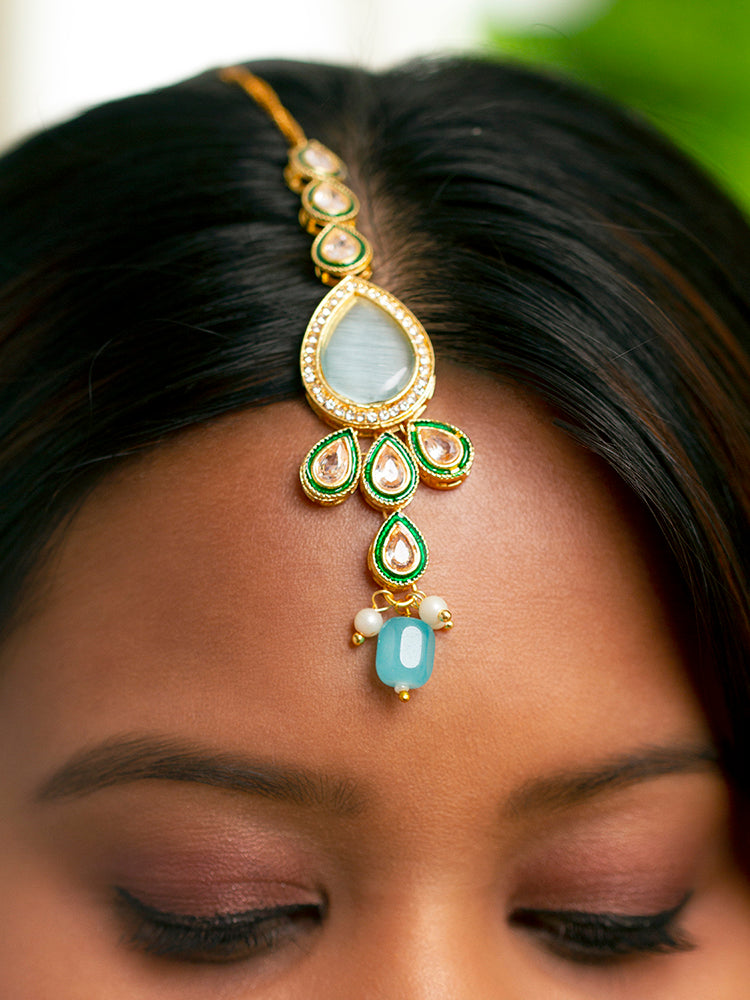 Close-up of a women wearing an ornate traditional Sky Blue Choker jewellery set and earrings and maangtikka with Kundan, Monalisa Stone, American Diamonds, Beads and Reverse American Diamonds and tumble stones. A graceful woman wearing a trending Colored Stone necklace for a 2026 wedding celebration. Elegant wedding jewelry look featuring a premium artificial Colored Stone necklace.