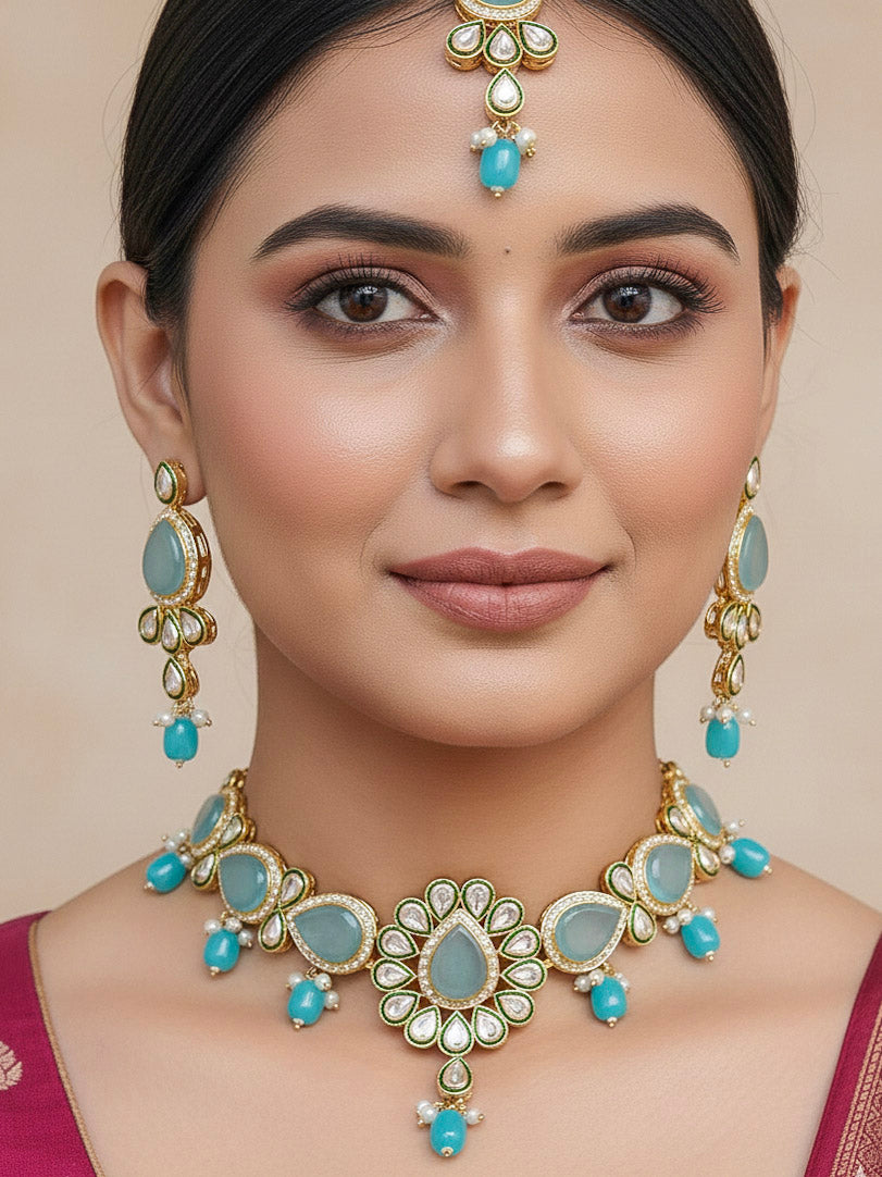 Close-up of a woman wearing an ornate traditional Sky Blue Choker jewellery set and earrings and maangtikka with Kundan, Monalisa Stone, American Diamonds, Beads and Reverse American Diamonds and tumble stones. A graceful woman wearing a trending Colored Stone necklace for a 2026 wedding celebration. Elegant wedding jewelry look featuring a premium artificial Colored Stone necklace.